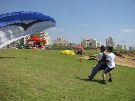 מדריך ותלמיד מתרגלים שליטה קרקעית בכנף על הדשא